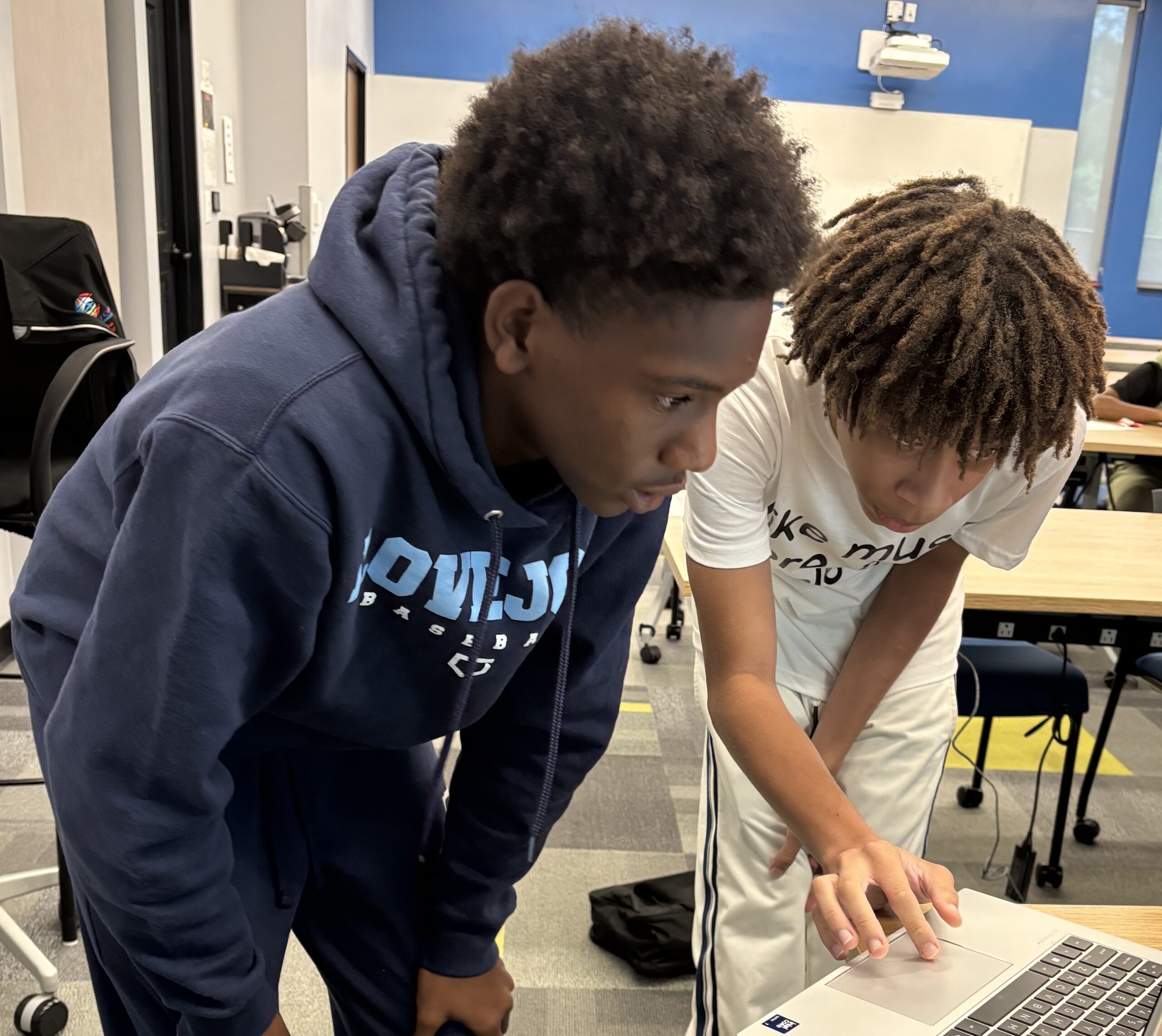 two students working together on laptop